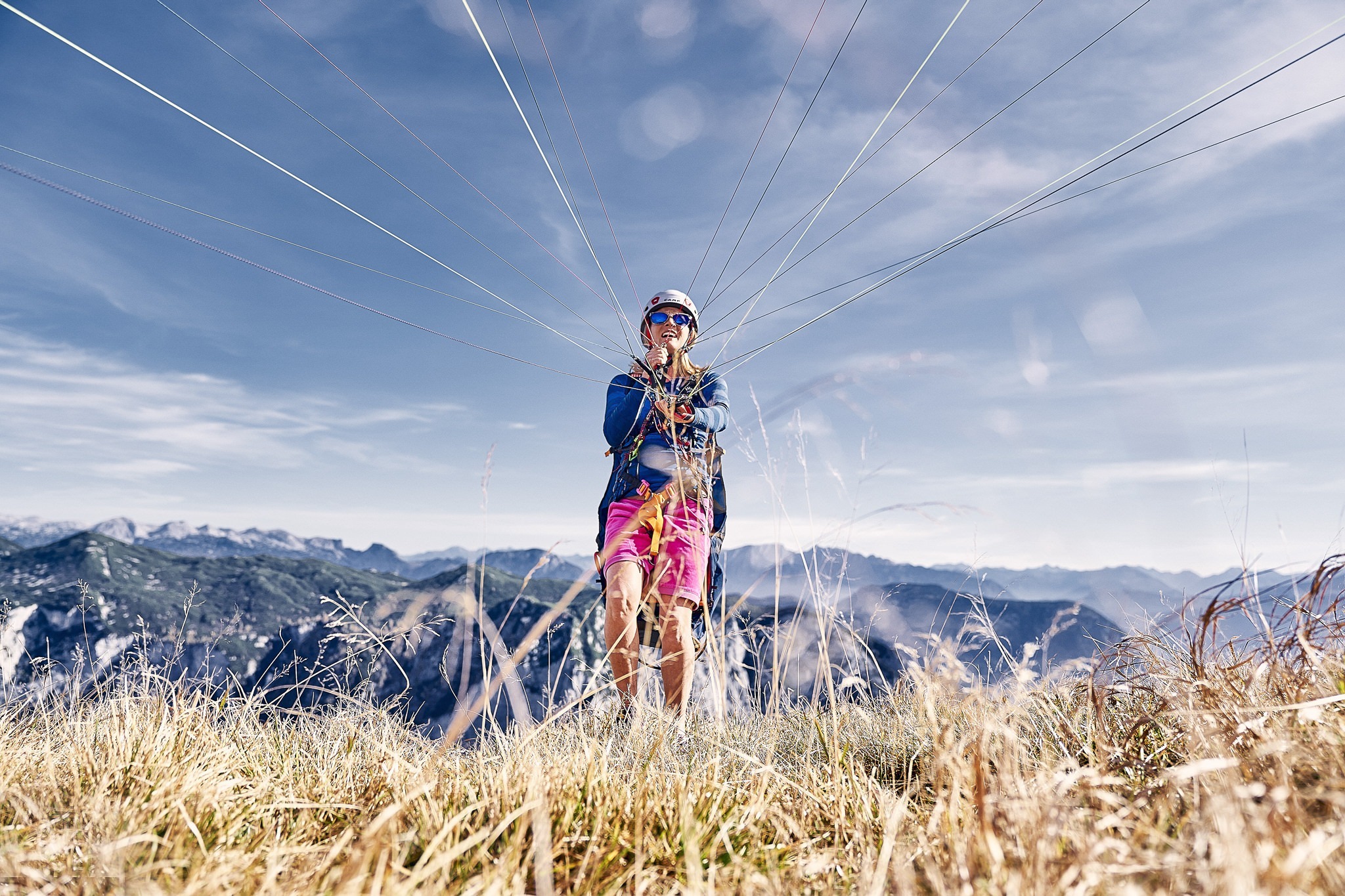 Sport- und Peoplefotografie für Woody Valley, Trento Sportfotografie: Junge Frau startet mit ihrem Gleitschirm in den Bergen.