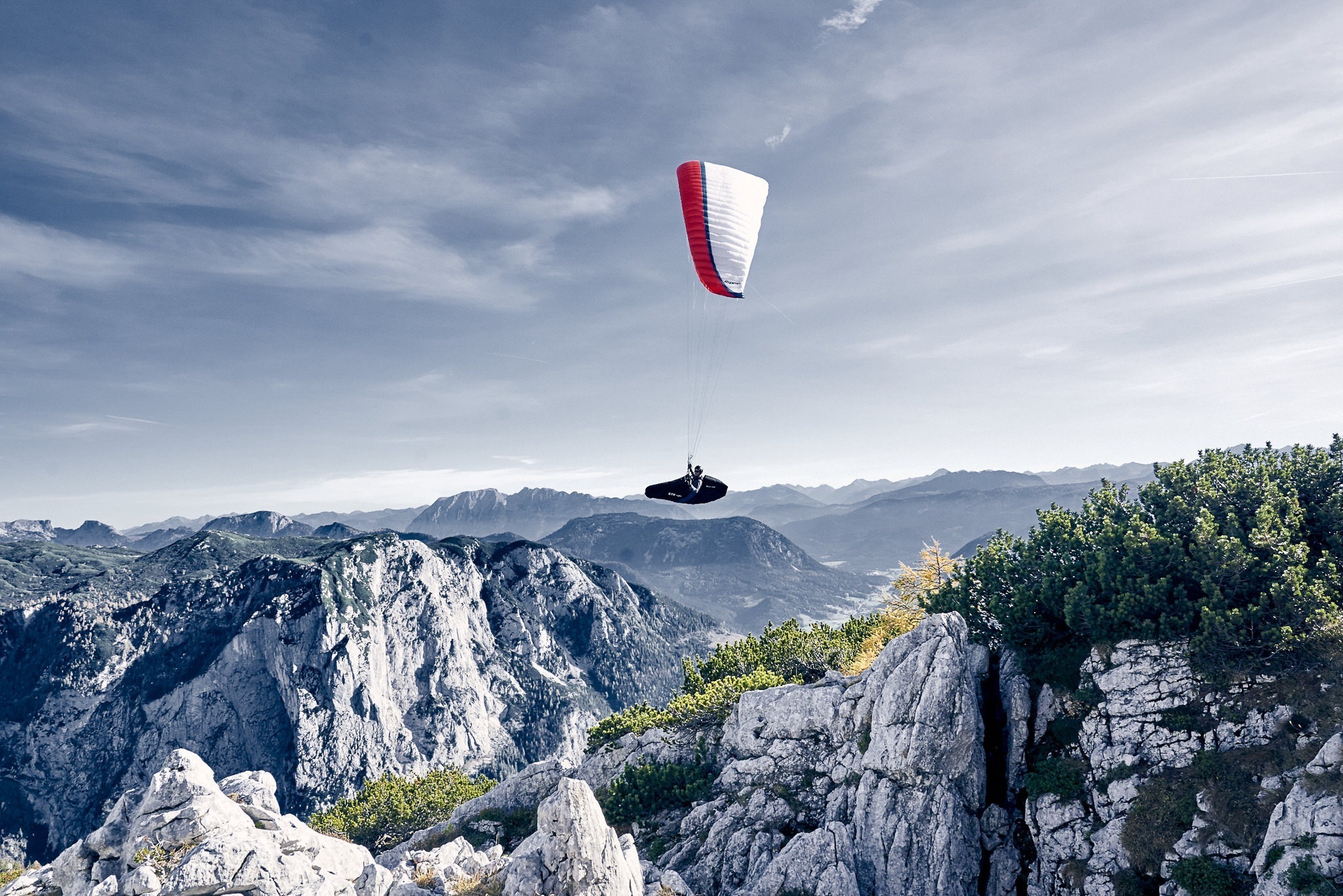 Am-Loser_Bad_Aussee_photo-montana-de Paraglider im Flug über alpiner Berglandschaft, Sportfotografie.