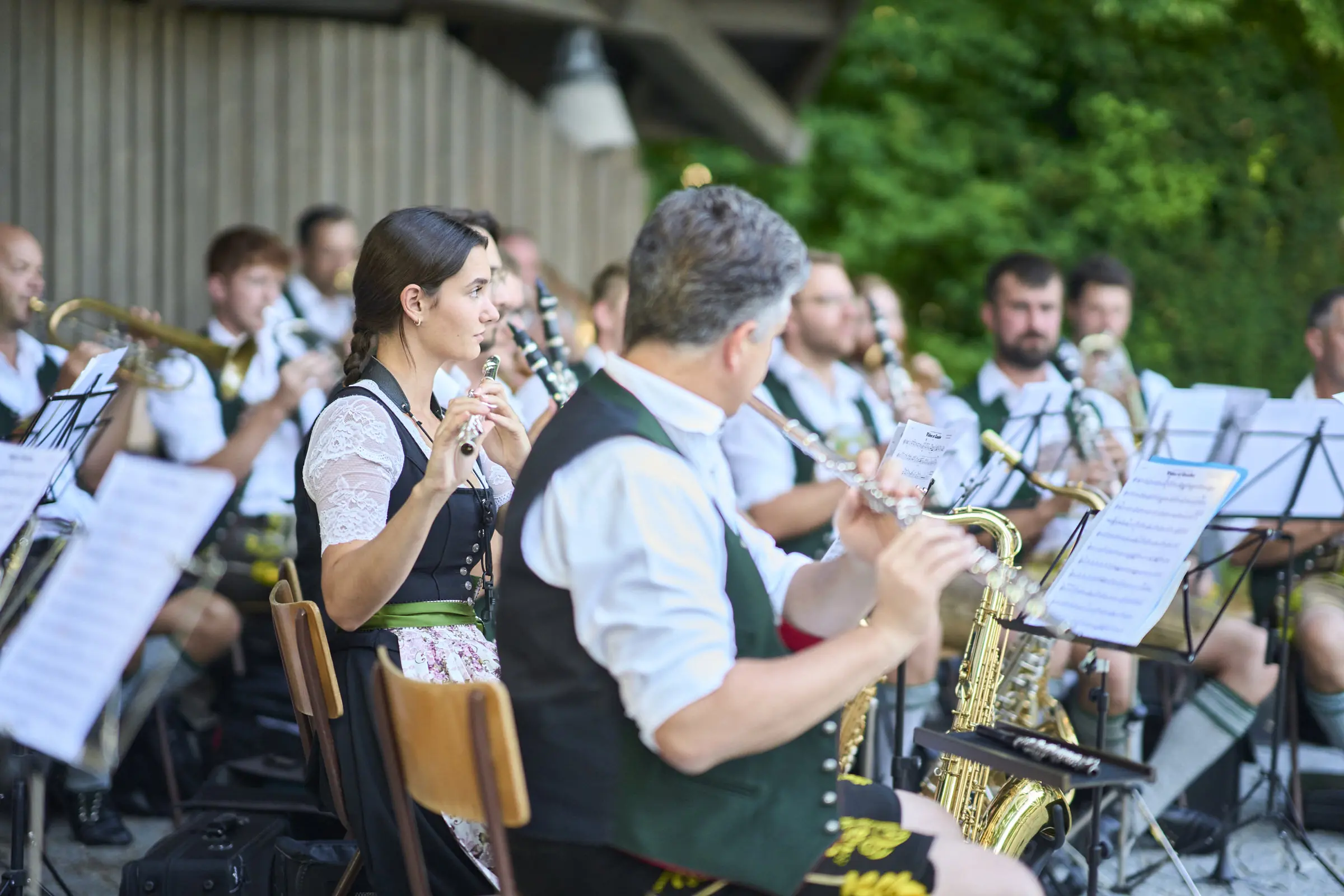 Blaskapelle in Tracht spielt Musikinstrumente auf einer Bühne.