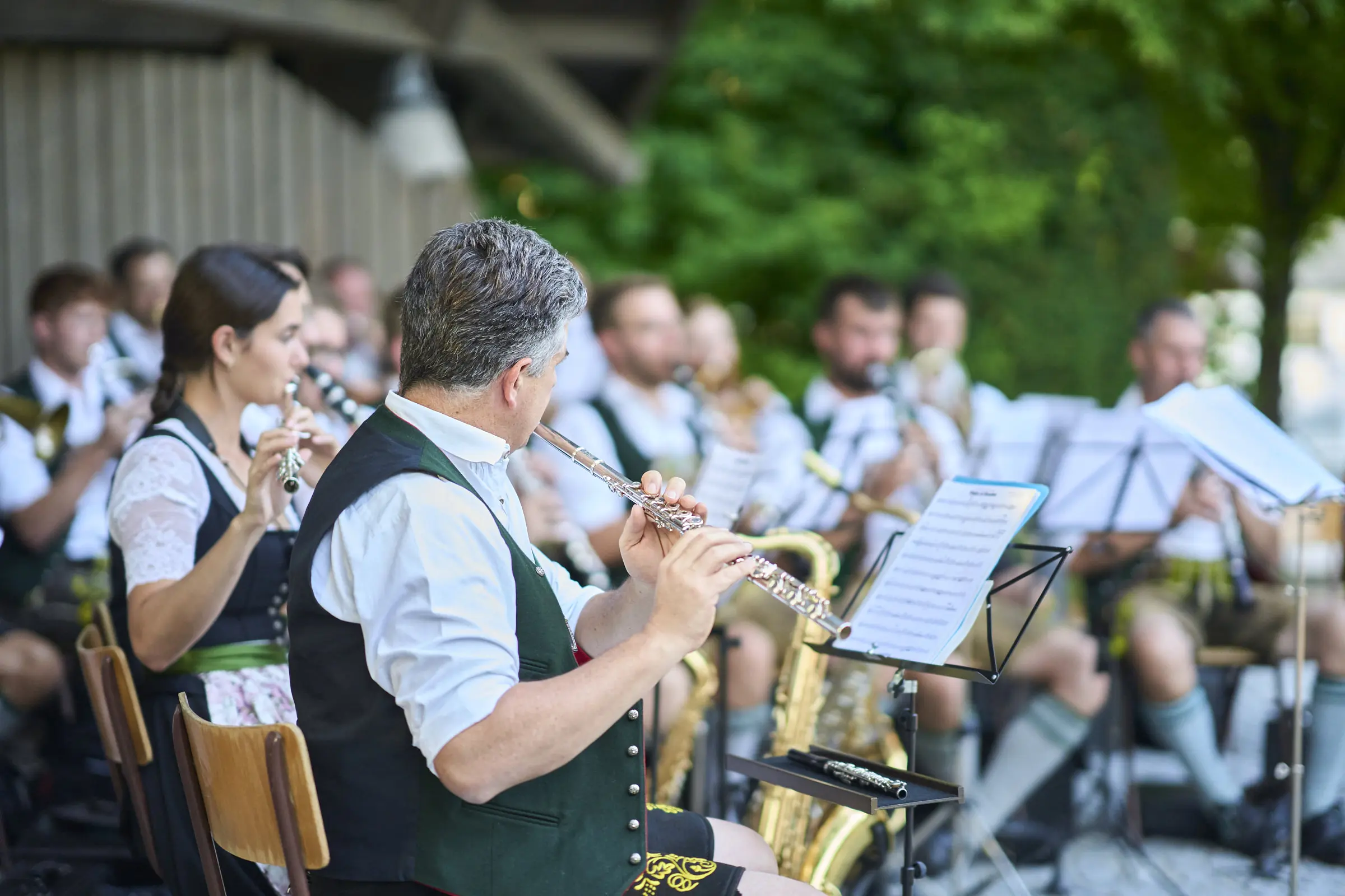 Blaskapelle spielt in traditioneller Tracht auf Flöten und Saxophonen.